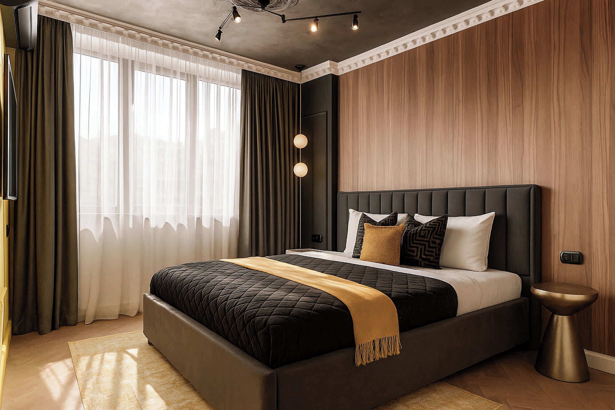 A modern bedroom with a large bed, a bedside table, and a wall-mounted light fixture.