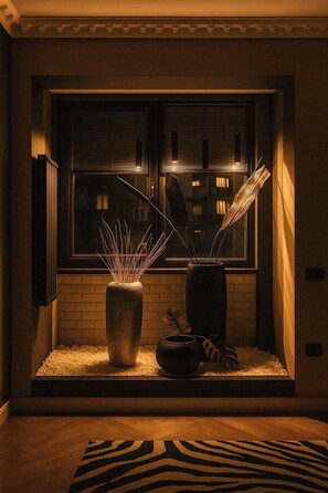 A cozy room with a window, a radiator, and two vases with plants.