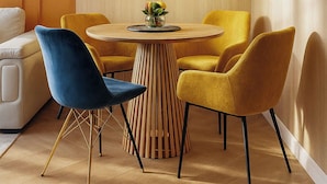 A modern dining area with a round table, two chairs, and a pendant light. - Qult·co - Huxley (București)