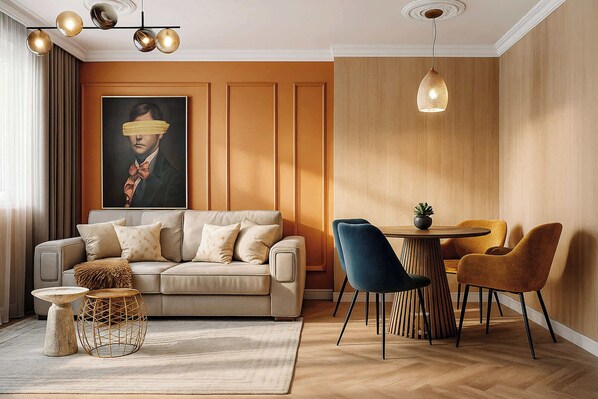 A modern living room with a sofa, a coffee table, and a dining area with chairs.