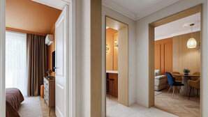 A hotel room with a bed, a desk, a chair, and a dining area with a table and chairs. - Qult·co - Huxley (București)