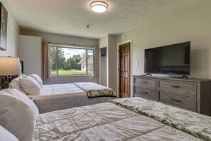 Una habitación de hotel con dos camas, televisión y cómoda.