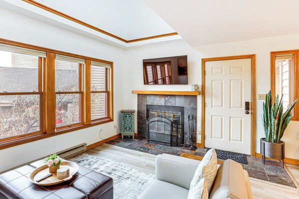 A spacious living room with a fireplace, large windows, and a cozy seating area. - 2 Mi to Dtwn Durango: Family Resort Retreat! (Durango)