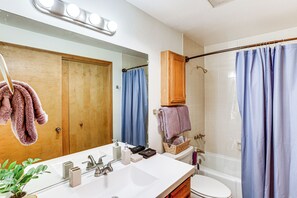 A bathroom with a white sink, wooden cabinets, a mirror, a shower curtain, and a towel rack. - 2 Mi to Dtwn Durango: Family Resort Retreat! (Durango)