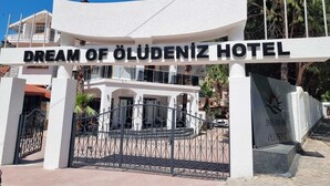 La entrada al Hotel Dream of Olyudeniz, con fachada blanca y letrero negro.