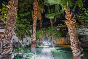A pathway flanked by palm trees and tropical plants, leading to a building entrance. - Dream Of Ã–lÃ¼deniz - All inclusive (Fethiye)