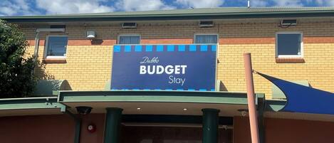 A building with a sign that reads "Dubbo BUDGET Stay".
