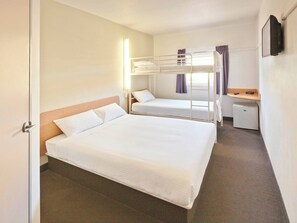 A hotel room with a large bed, a smaller bed, a desk, and a refrigerator. - DUBBO BUDGET STAY (Dubbo)