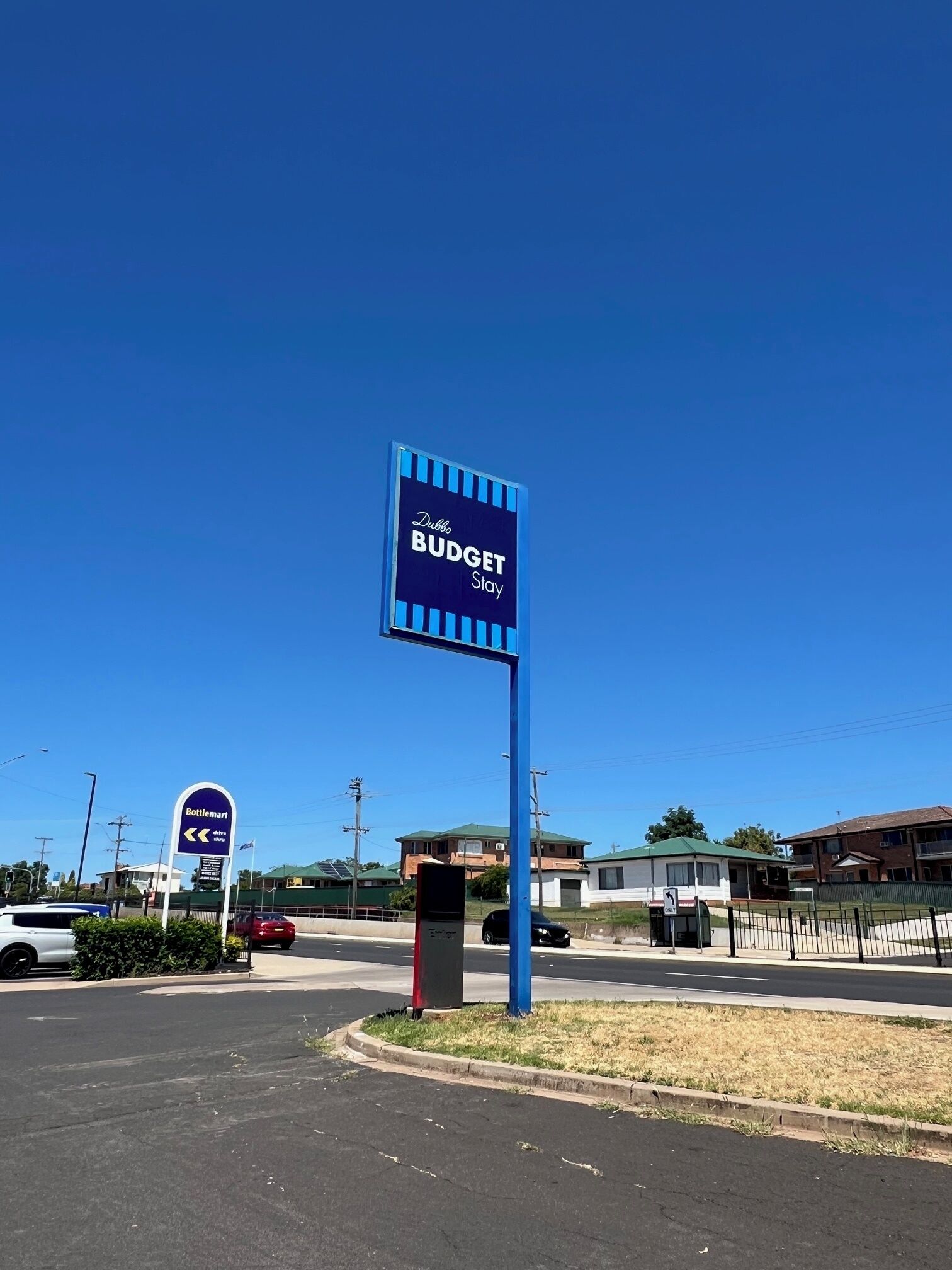 A sign for Dubbo Budget Stay with a clear blue sky in the background.