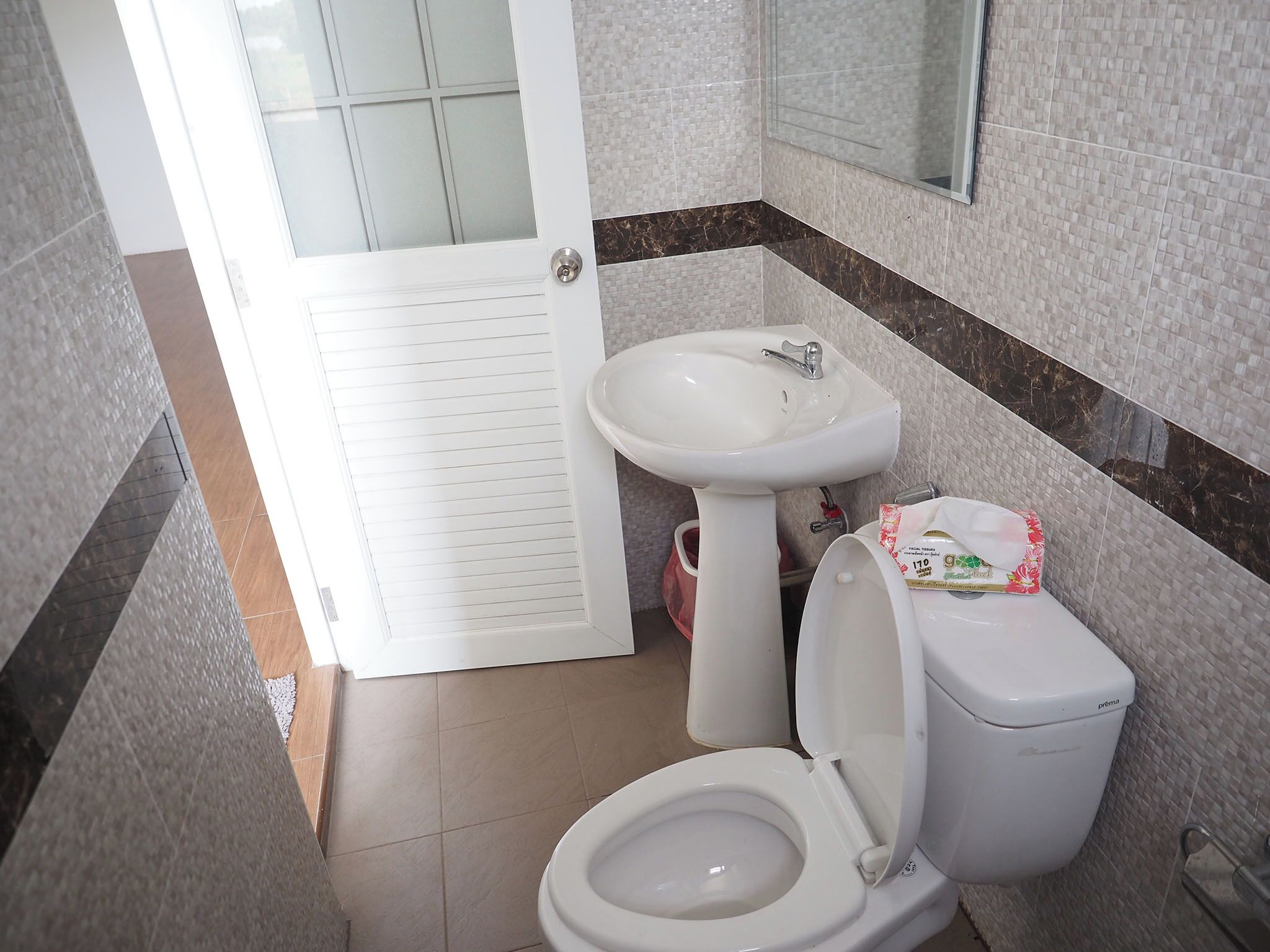Un bagno con il water, un lavandino e uno specchio.
