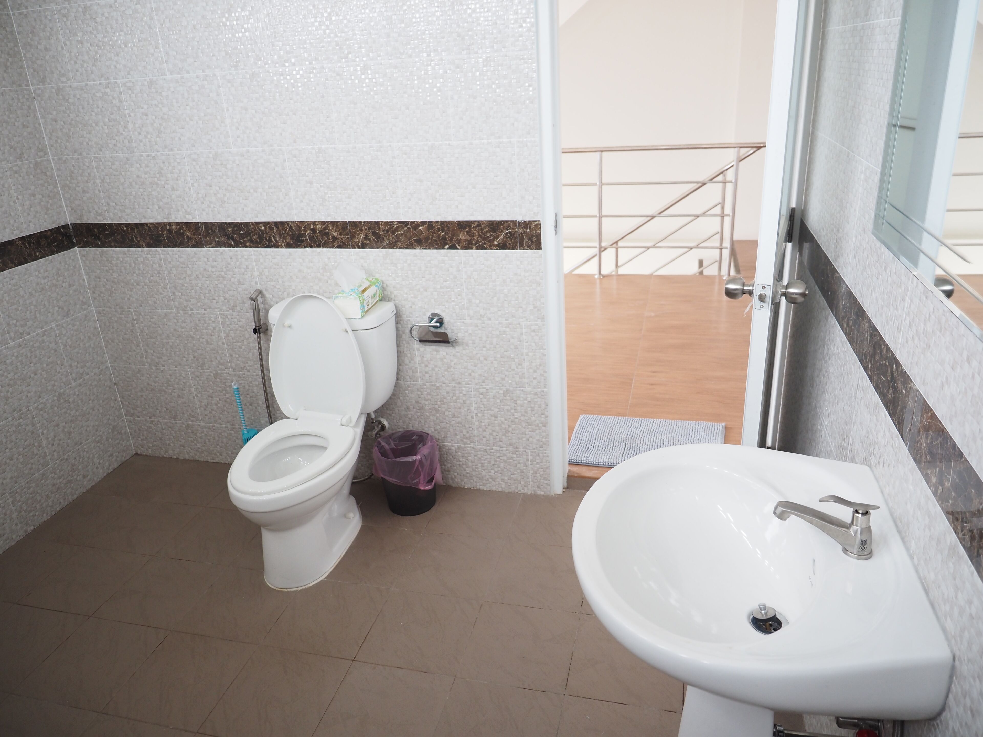 A bathroom with a toilet, a sink, and a shower area.