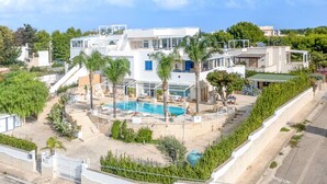 Une villa moderne dotée d’une piscine, de plusieurs niveaux et offrant une vue sur le paysage environnant.