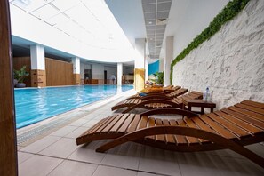 Relax by the pool surrounded by lush greenery and modern design.