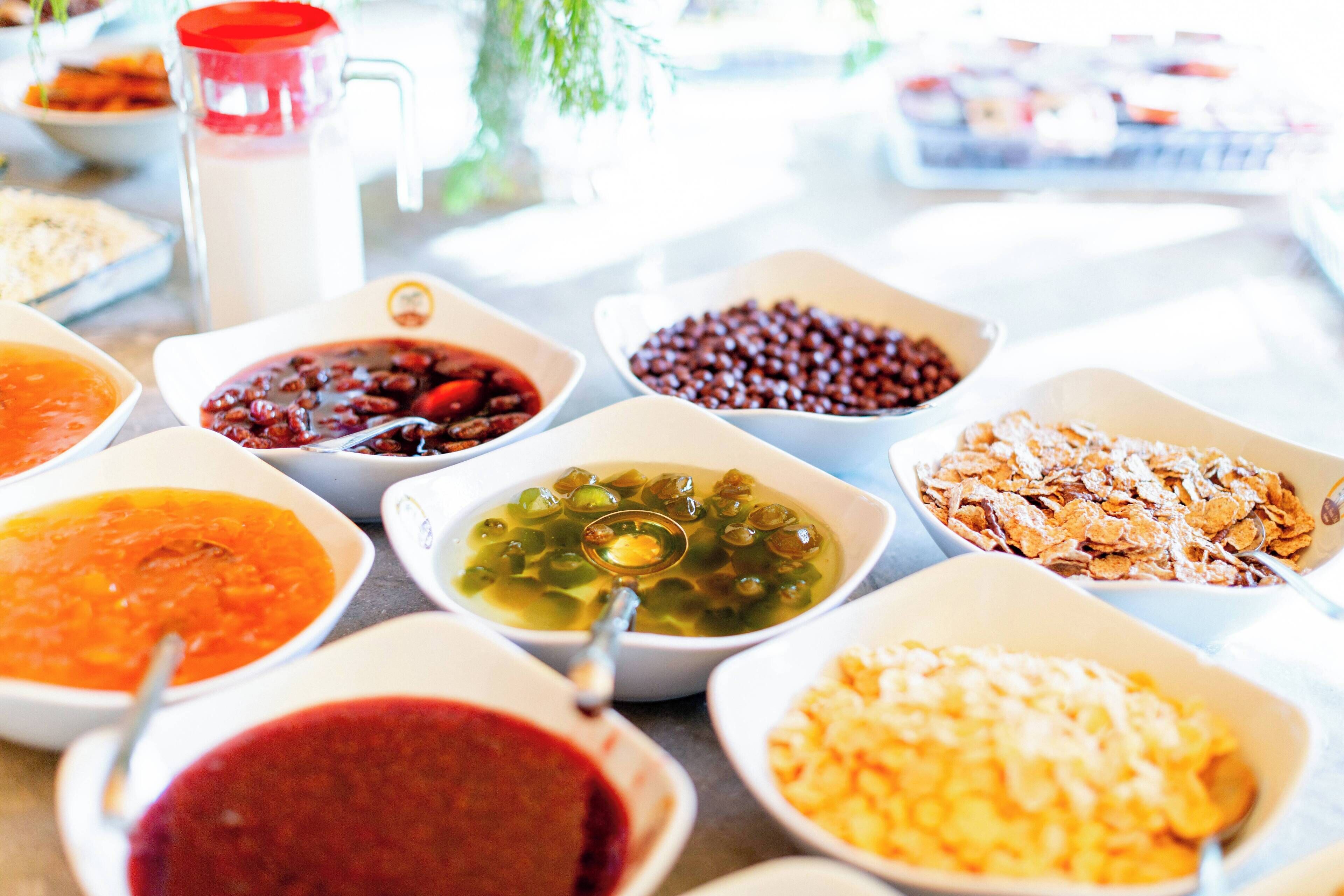 A variety of bowls containing different types of food, including soups and grains, arranged on a table.
