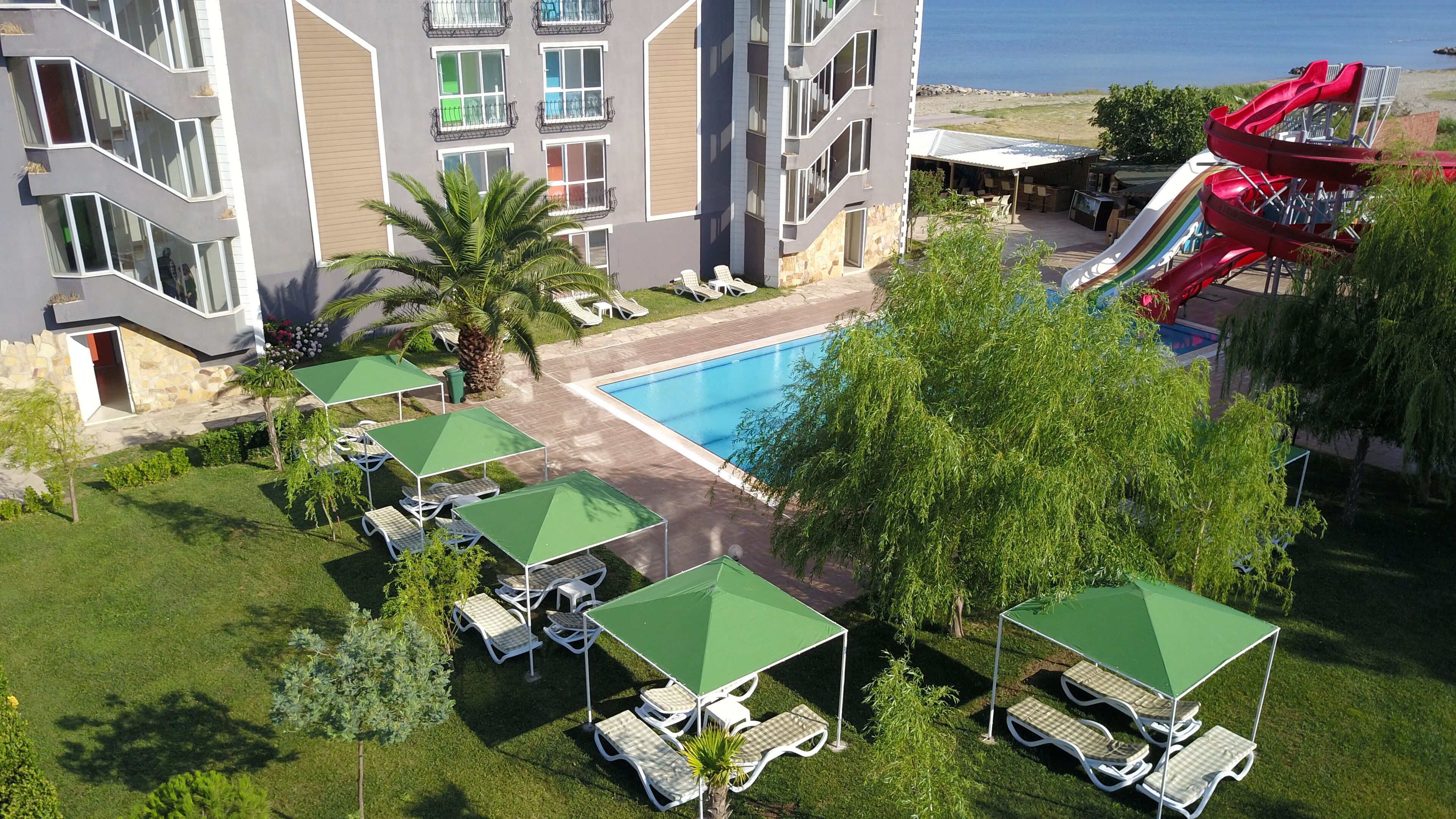 A hotel with a pool, outdoor seating, and a slide.
