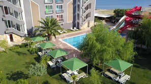 Ein Hotel mit Pool, Außenbereich und Rutsche.