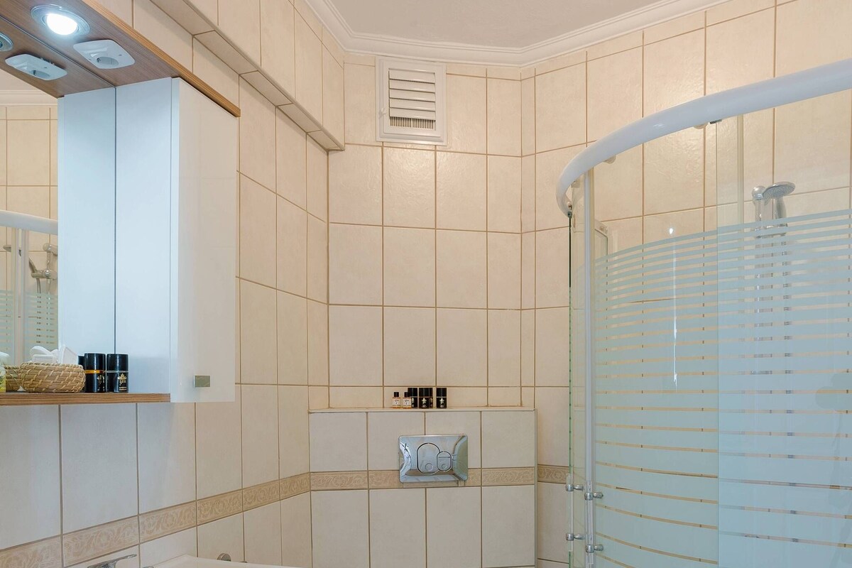 Een badkamer met een wit wastafelmeubel, toilet en douchecabine.
