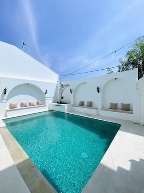 A rectangular swimming pool with clear blue water, surrounded by white walls with arched niches containing beige cushions. - 6BR, Large Group, GREAT VALUE, Free Daily Housekeeping, Strategic Location! (Bali)