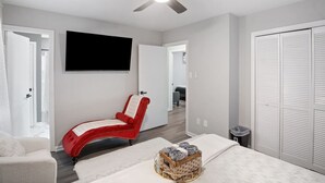 A modern bedroom with a bed, a red massage chair, a TV, and a wardrobe. - Charming Retreat w/ Pool Table in Chesterfield! (Chesterfield)