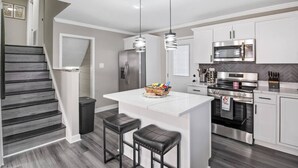 A modern kitchen with a central island, stainless steel appliances, and a herringbone-patterned backsplash. - Charming Retreat w/ Pool Table in Chesterfield! (Chesterfield)