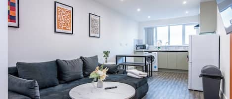 A modern living room with a sofa, a coffee table, and artwork on the wall.