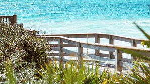 A wooden deck overlooking a turquoise ocean with a clear sky.