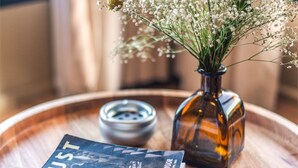 A wooden tray with a vase of white flowers, a book titled 'DUST', and a small container. - Studio Dwelling (Tigoni)