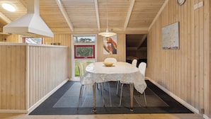 A wooden interior with a round table, chairs, a large window, and a map on the wall. - Cozy summer house near Hals (Hals)
