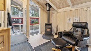 A cozy room with a fireplace, a leather chair, and a wooden interior. - Cozy summer house near Hals (Hals)