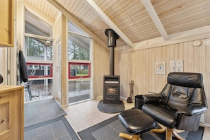 A cozy room with a fireplace, a leather chair, and a wooden interior.