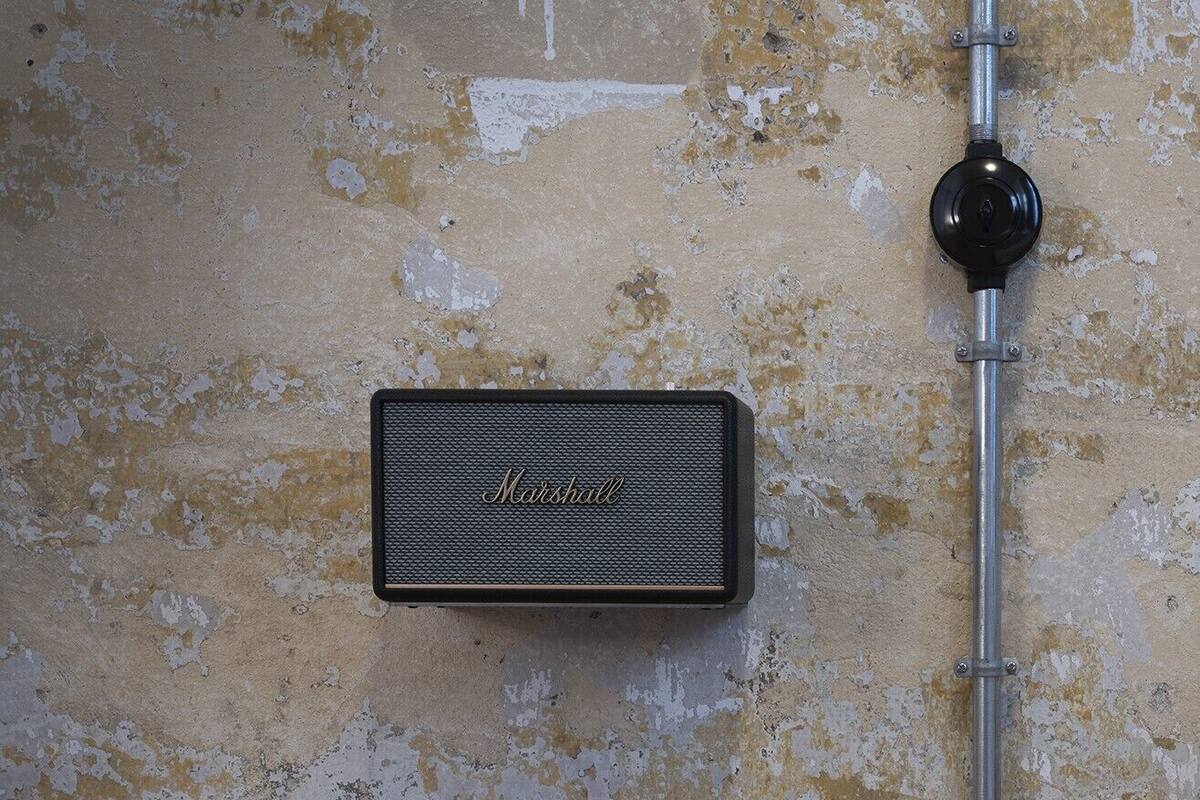 A vintage Marshall amplifier mounted on a textured wall.