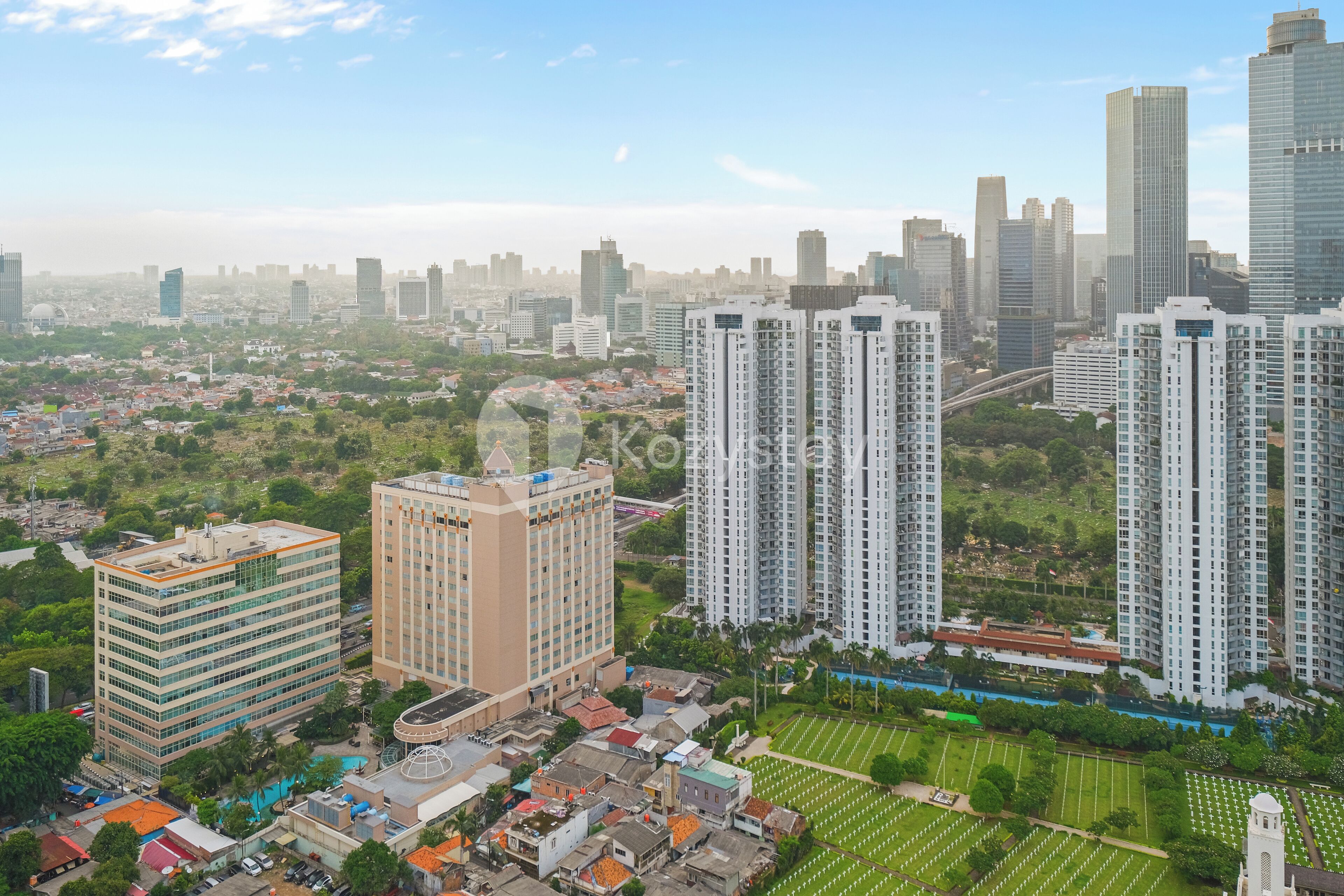 A high-rise building with a modern design, surrounded by a mix of residential and commercial structures.