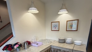 Een badkamer met een marmeren wastafel, twee hanglampen, een handdoekhouder en een lijst met een afbeelding aan de muur.