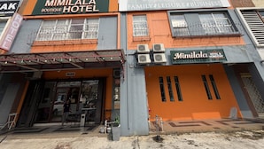 Een gebouw met een bord waarop 'Mimilala Boutique Hotel' en 'Mimilala Hotel & Homestay' staat, wat aangeeft dat er familievriendelijke, vrijetijds- en zakelijke faciliteiten zijn.