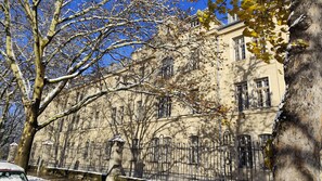 A historic building with a classic architectural style, featuring multiple windows and a prominent entrance gate. - Appartements Schwere Reiter Straße (Munich)