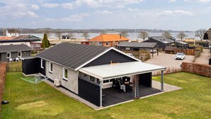 A modern house with a large garage and a covered outdoor seating area.