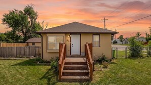 Une maison de plain-pied avec un porche à l’avant, une clôture en bois et une pelouse bien entretenue.