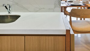 A modern kitchen with a sink, wooden cabinets, and two upholstered chairs. - Hanae by Kozystay - Kuningan (Jakarta)