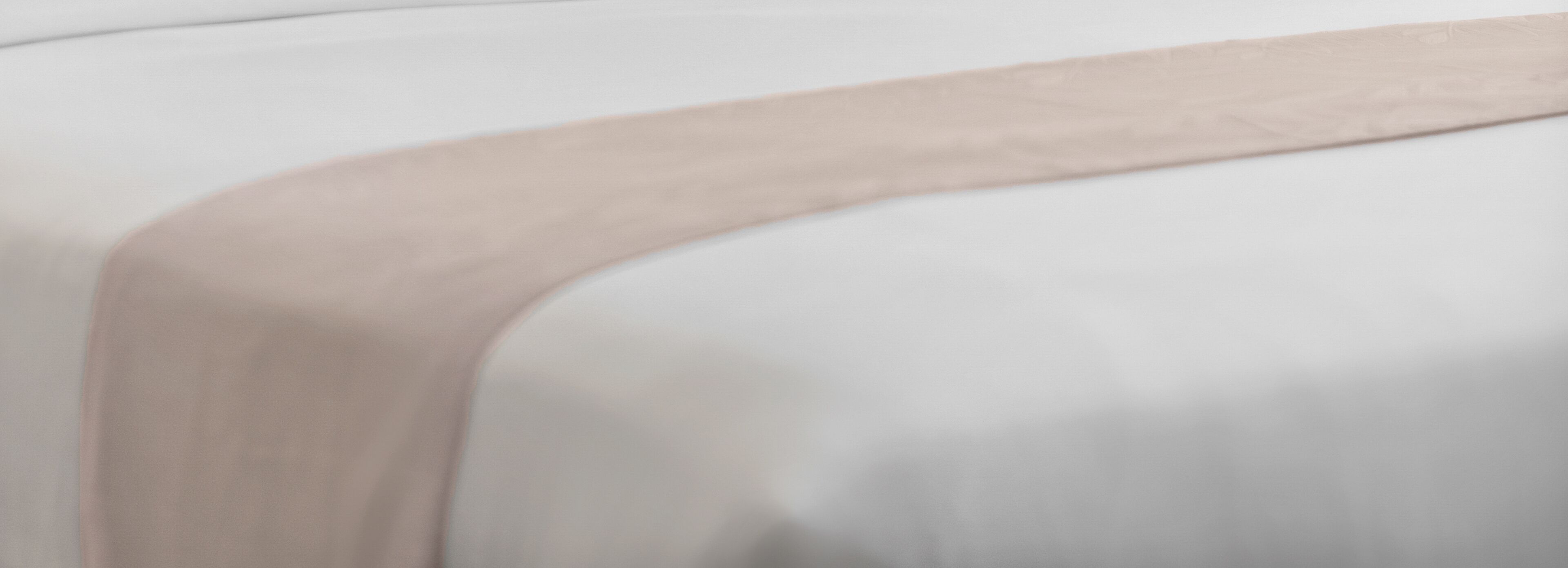 Primer plano de una tela blanca con un detalle en beige claro.