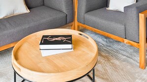 A modern living room with grey sofas, a wooden coffee table, and a small rug. - Hanae by Kozystay - Kuningan (Jakarta)
