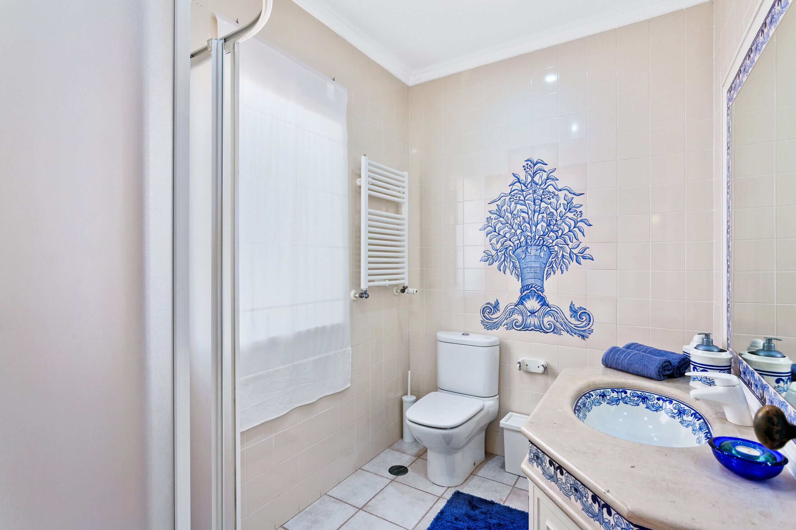 A bathroom with a toilet, sink, and shower.