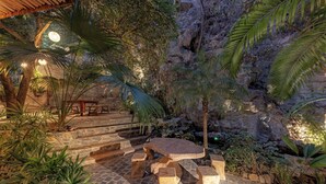 An outdoor patio with stone seating and steps leading to a stone wall. - Trang An Aroma Homestay (Ninh Binh)