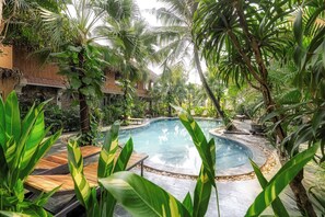 A pool surrounded by lush greenery and wooden deck seating. - Trang An Aroma Homestay (Hoa Lu)