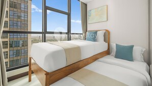 Un hotel moderno con una cama grande, vistas de la ciudad y una ventana con cortinas.