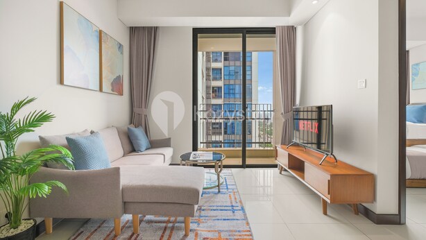 Una sala de estar moderna con un sofá, una mesa de centro y un televisor sobre un mueble.