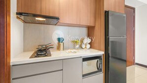 Una cocina moderna con armarios de madera, estufa integrada, refrigerador y microondas.