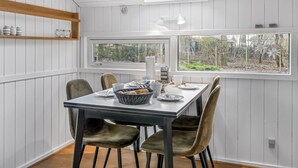 A dining area with a table set for six, a skylight, and a view of the outdoors. - "Reino" - 30km from the sea by Interhome (Toftlund)