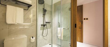 Une salle de bain moderne avec une douche à parois de verre, des toilettes et un porte-serviettes.