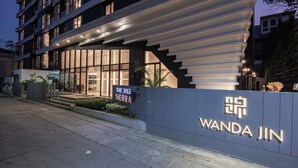 Una entrada de hotel moderna con un cartel que dice "Wanda Jin" y una placa que indica "El Caso Sierra".