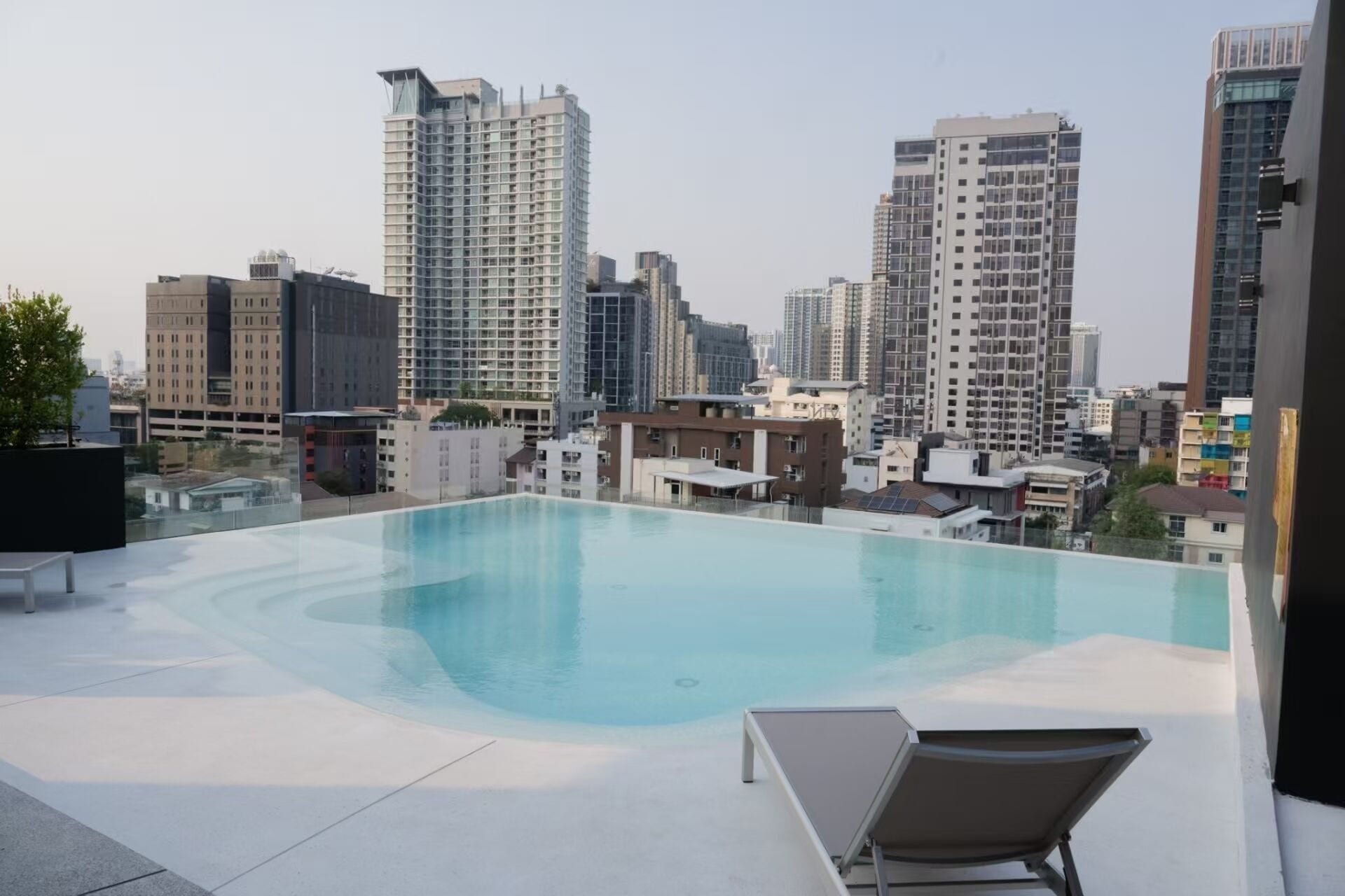 A rooftop pool with a cityscape view, surrounded by modern buildings.
